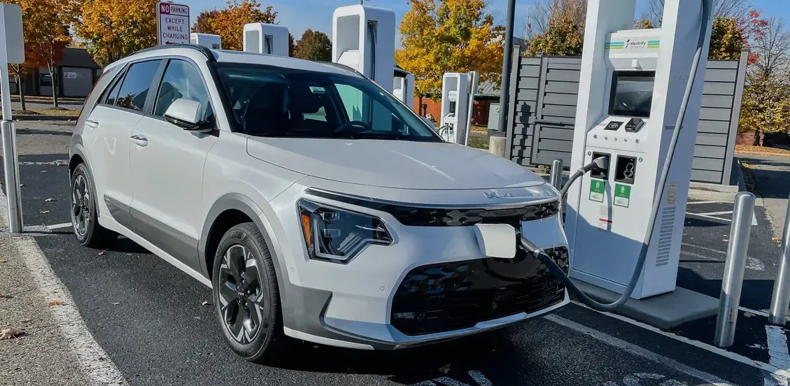 How to Charge Kia Niro: White Kia Niro EV charging at an Electrify America station