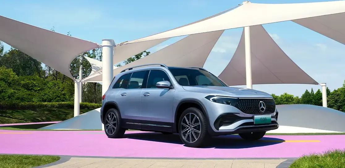How to charge Mercedes EQB: parked in front of huge umbrella area in a park rest area.