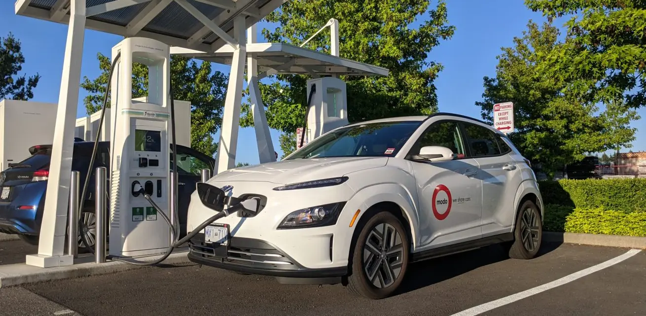 How to charge Hyundai Kona: White Hyundai Kona charging at Electrify America station