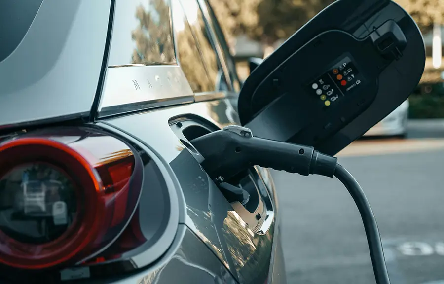 Close-up of a CCS charging connector plugged into an EV during daytime charging