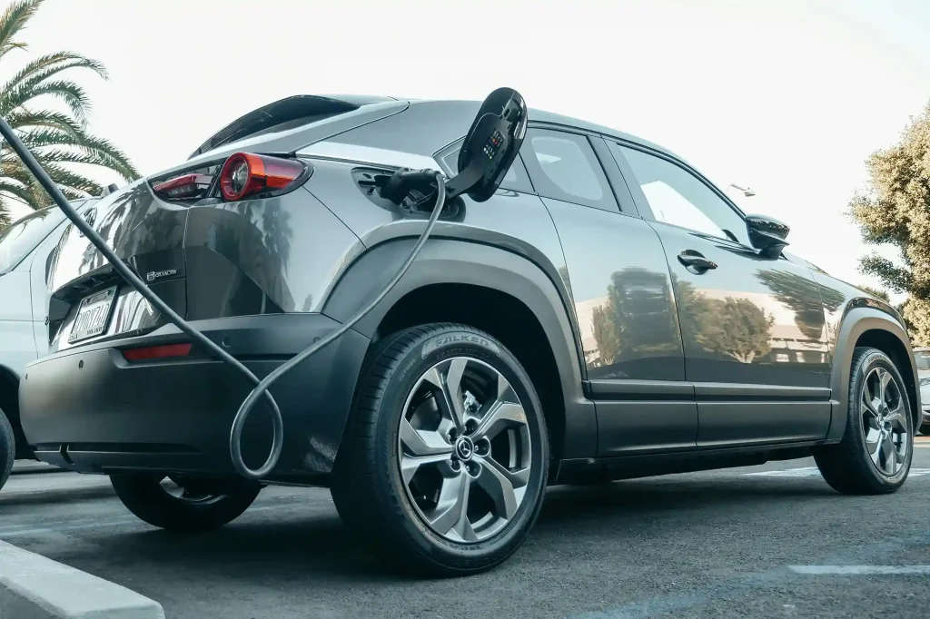 Electric vehicle being charged at a public parking lot with a portable ev charger.