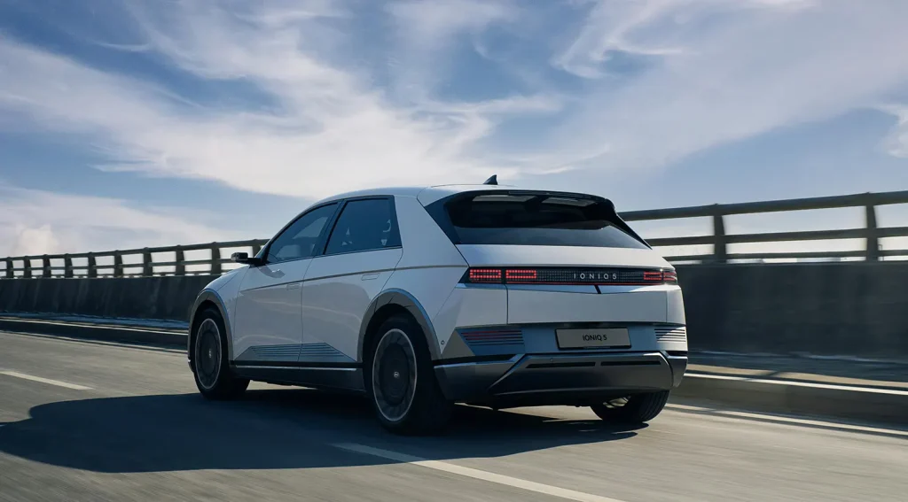 Electric car on open road highlighting benefits of portable EV charger for road trips