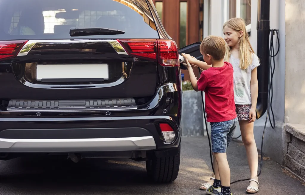 Children plugging in EV with portable charger