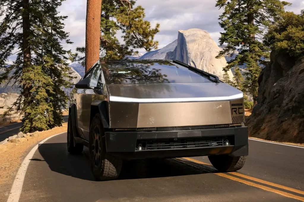 Tesla Cybertruck driving on a scenic road – futuristic electric truck design