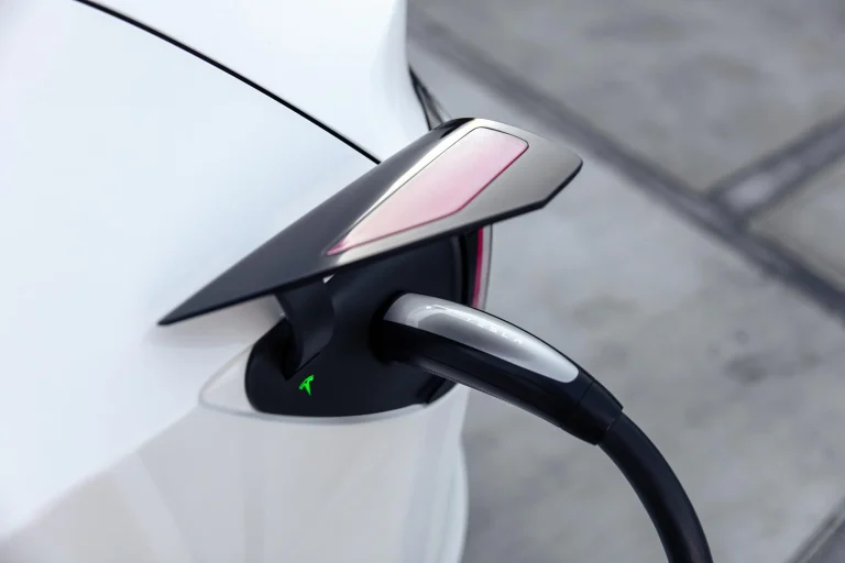 Close-up of a Tesla using the SAE J3400 charging plug at a North American charging station