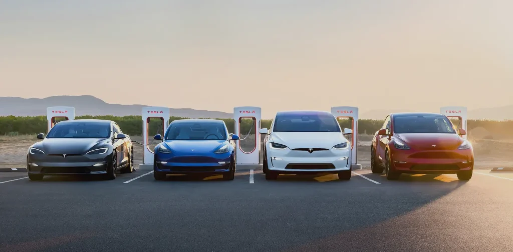 Multiple Tesla vehicles charging at a Supercharger station using the SAE J3400 connector