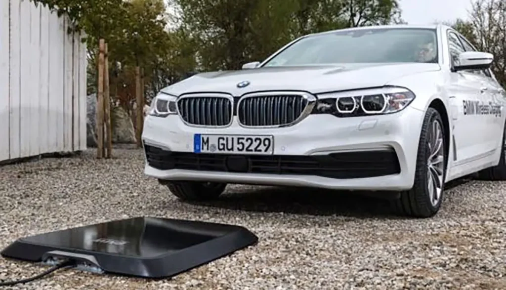 BMW wireless EV charging pad demonstration with vehicle parked above charging plate