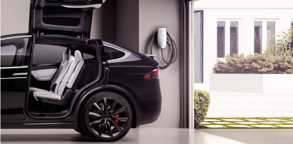 model x parked at a garage with wall box at its back demostrating How to charge a tesla model x at home