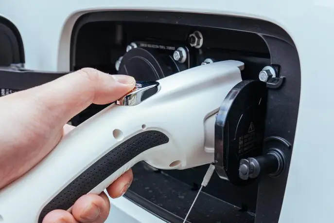 Home EV Charger Readiness Assessment-Close-up of an EV charging connector being plugged in during a home charger assessment