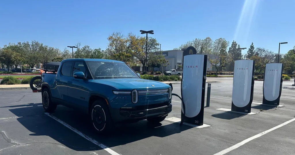 Rivian R1T charging at a Tesla Supercharger using the SAE J3400 charging standard