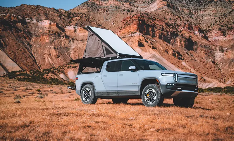 Rivian R1T electric truck using Vehicle-to-Load (V2L) to power camping setup in the desert