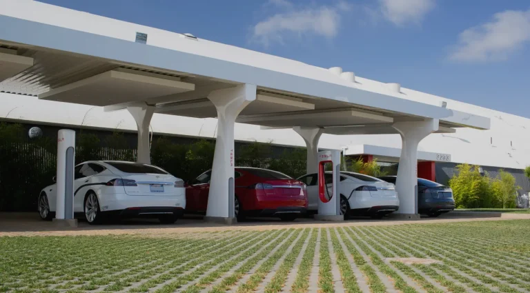 Tesla vehicles charging at a Level 3 EV charger station with DC fast charging canopy
