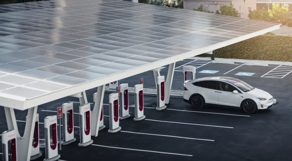 Large Tesla Supercharger site featuring multiple Level 3 DC fast chargers under a solar canopy