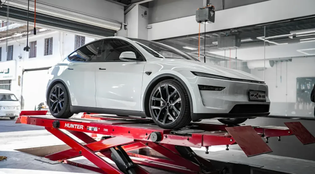 Tesla in a repair shop illustrating tesla battery replacement cost options