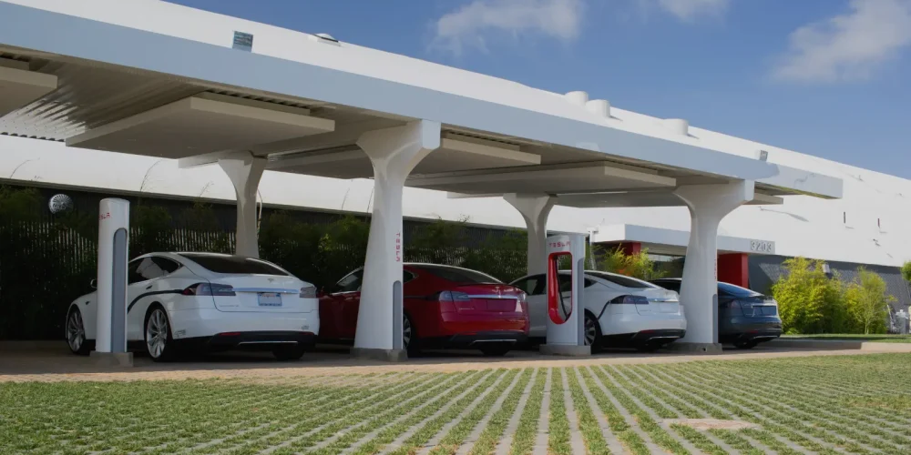 Tesla vehicles charging at a Level 3 EV charger station with DC fast charging canopy