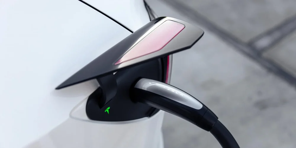 Close-up of a Tesla using the SAE J3400 charging plug at a North American charging station