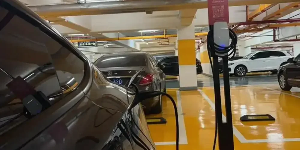 Tesla destination charger installed in a parking garage for convenient Level 2 charging