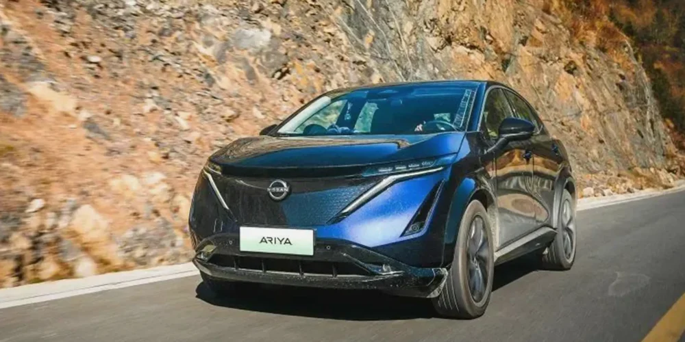 Blue Nissan Ariya driving fast on mountain road showcasing power and performance